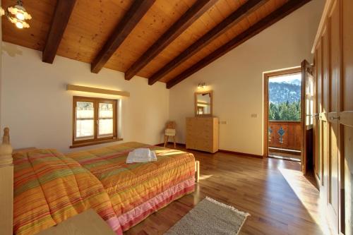 una camera da letto con un letto e una grande finestra di Albergo Diffuso Sauris in Lateis a Lateis
