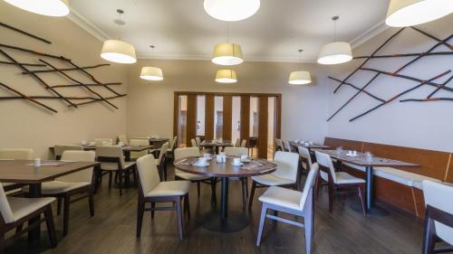 a dining room with tables and chairs and lights at Hotel Antofagasta in Antofagasta