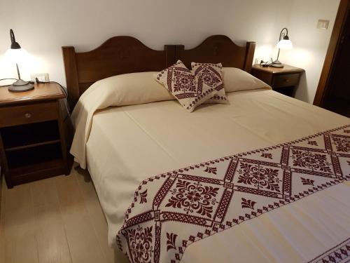 Un dormitorio con una cama grande con dos mesitas de noche. en Casa Vacanze La Pavoncella, en Iglesias