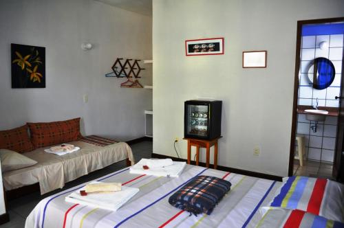 a room with two beds and a tv in it at Pousada Casa da Geleia in Lençóis