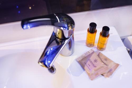a bathroom sink with a faucet and two bottles of soap at Apartament Trójkąty i Kwadraty in Łańcut