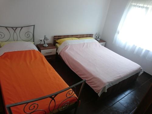 2 nebeneinander sitzende Betten in einem Schlafzimmer in der Unterkunft Apartmani Bartolić in Biograd na Moru