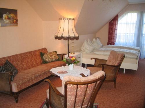a living room with a couch and a table at Pension Kordula Straub in Waldfenster