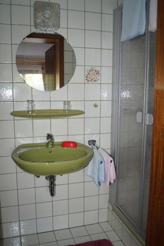 a bathroom with a green sink and a mirror at Pension Kordula Straub in Waldfenster
