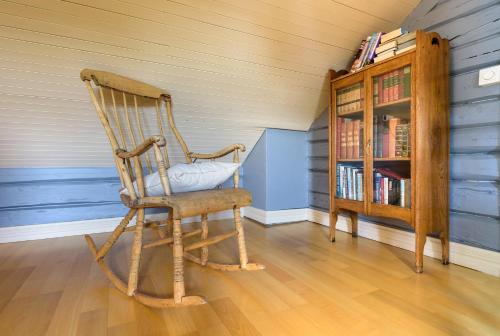 a wooden rocking chair in a room with a book shelf at Kabelvåg Feriehus & Camping in Kabelvåg