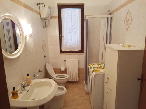 ヴィッラノーヴァ・ディ・オストゥーニにあるAppartamento La Rosa Dei Ventiのバスルーム(洗面台、トイレ、鏡付)