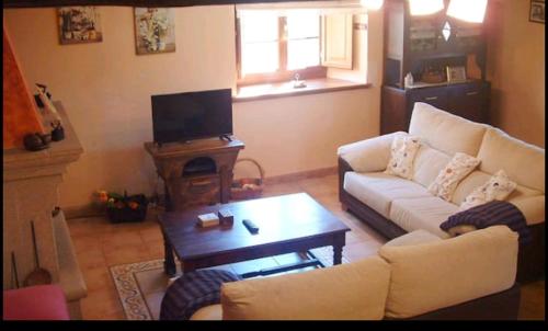 a living room with a couch and a coffee table at Casa Rural Oza dos Ríos in Oza dos Ríos