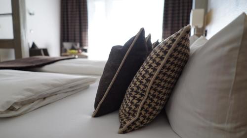 a group of pillows sitting on a bed at Hotel Quellenhof in Grainau