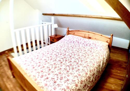 Cama de madera en habitación con cuna en Lumières B&B en Lille