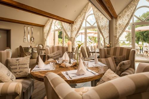 a dining room with tables and chairs and windows at Das 53°Hotel in Bad Zwischenahn