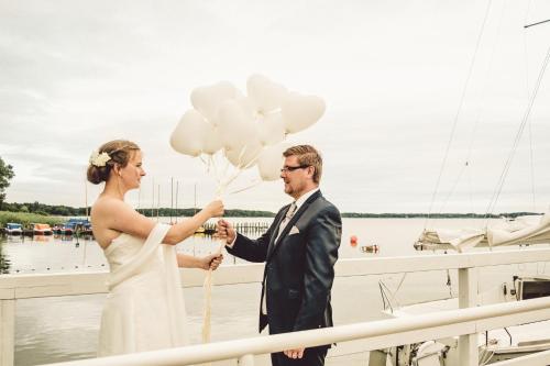 a bride and groom standing on a boat with balloons at Das 53°Hotel in Bad Zwischenahn