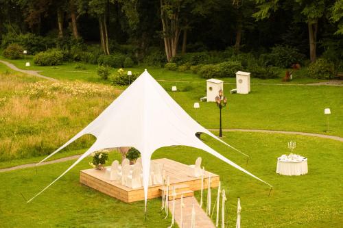 a white tent with chairs and a table in a field at Das 53°Hotel in Bad Zwischenahn