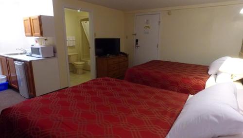 a hotel room with two beds and a television at Econo Lodge Inn & Suites in Saint John