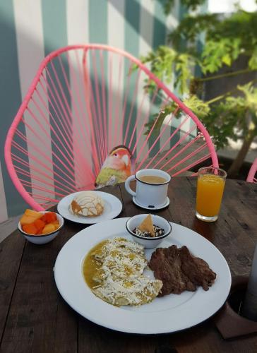 a table with plates of food and a bird on it at Mas Basico Hotel in Veracruz