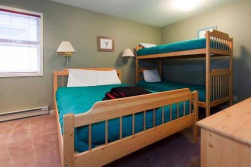 a bedroom with two bunk beds and a desk at Vacation Homes by The Bulldog- Henk's Haven in Silver Star