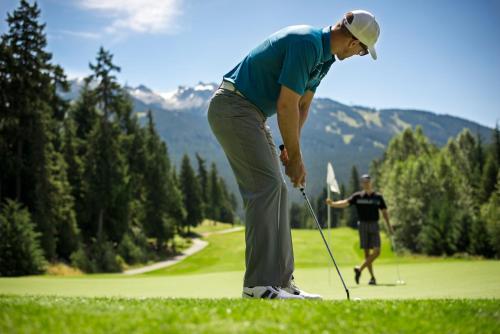 a man is playing golf on a golf course at Fairmont Chateau Whistler in Whistler