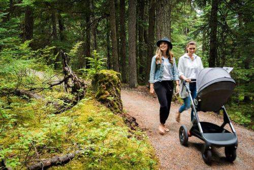 a woman walking down a trail with a stroller at Fairmont Chateau Whistler in Whistler