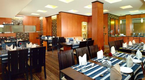 a dining room with tables and chairs in a restaurant at Hotel Aiswarya in Cochin