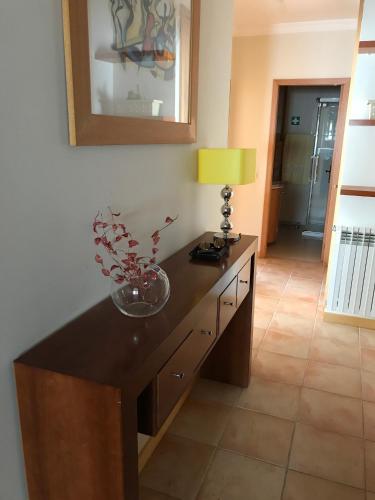 a room with a table with a vase of flowers on it at Varandas da Sandia in Vila Praia de Âncora