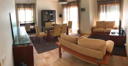 a living room with a couch and a table and chairs at Varandas da Sandia in Vila Praia de Âncora