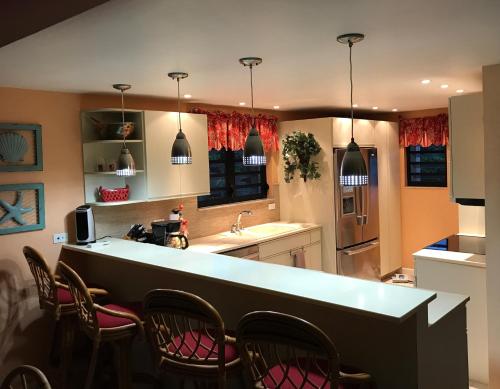 a kitchen with a bar with chairs around it at Pelican Cove Condo in Christiansted