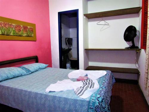 Un dormitorio con una cama con ropa. en Aracy Paraty, en Paraty