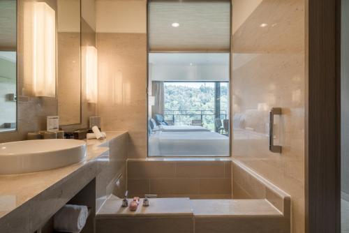 a bathroom with a sink and a shower at Fleur de Chine Hotel in Yuchi