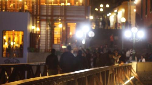 a group of people walking on a bridge at night at Casita Libertad Barranco in Lima