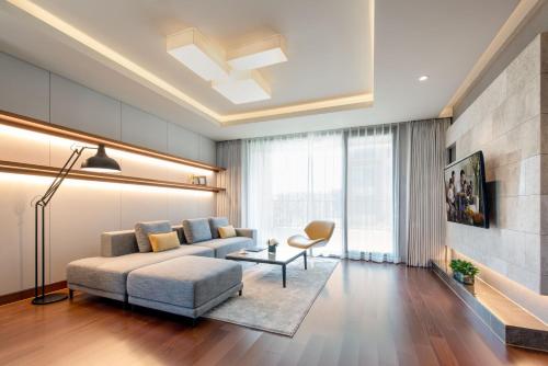 a living room with a couch and a table at Somerset Jeju Shinhwa World in Seogwipo