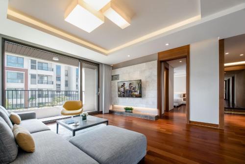 a living room with a couch and a large window at Somerset Jeju Shinhwa World in Seogwipo