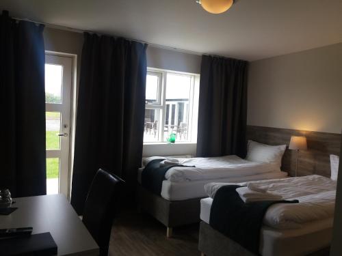 a hotel room with two beds and a window at Hotel Vos in Hella