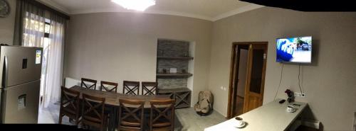 a kitchen with a table and chairs and a refrigerator at Hill House in Stepantsminda