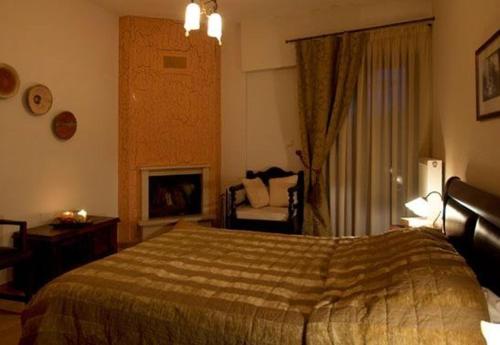 a bedroom with a bed and a chair and a fireplace at Akrolimnia in Kalyvia