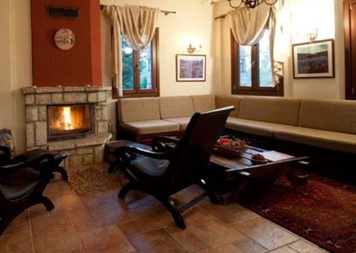 a living room with a couch and a fireplace at Akrolimnia in Kalyvia