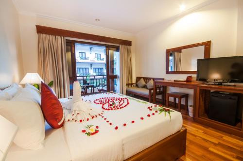 a bedroom with a large bed and a television at Saem Siemreap Hotel in Siem Reap