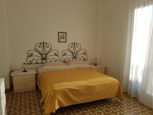 ヴィッラノーヴァ・ディ・オストゥーニにあるAppartamento La Rosa Dei Ventiのベッドルーム1室(黄色い毛布付きのベッド1台付)