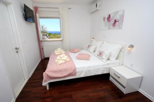 a small bedroom with a bed with two teddy bears on it at Villa Domus in Podstrana