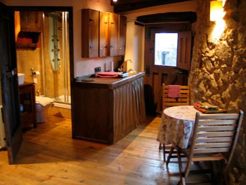 una cucina con bancone e tavolo con sedie di Apartamento La Muralla a Miranda del Castañar