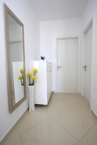 a white room with a mirror and a vase with yellow flowers at Villa Domus in Podstrana