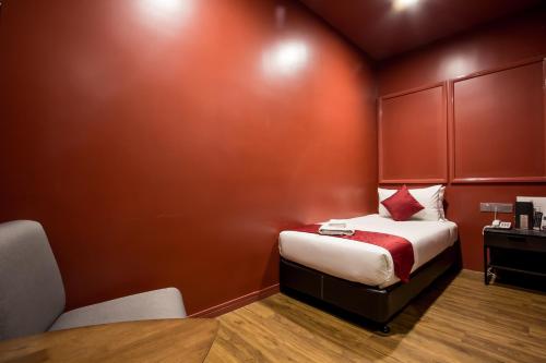 a small room with a bed and a table and chairs at Bloommaze Boutique Hotel Puchong in Puchong