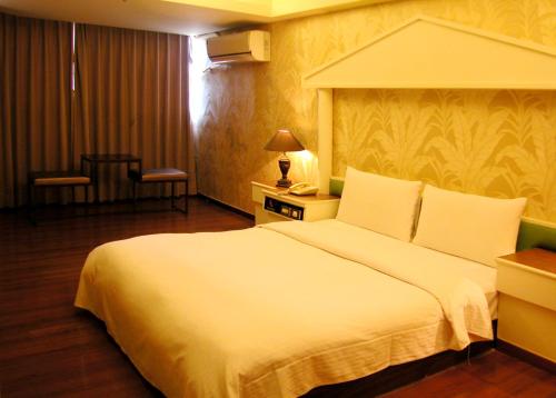 a bedroom with a large white bed in a room at Zaw Jung Business Hotel in Taichung