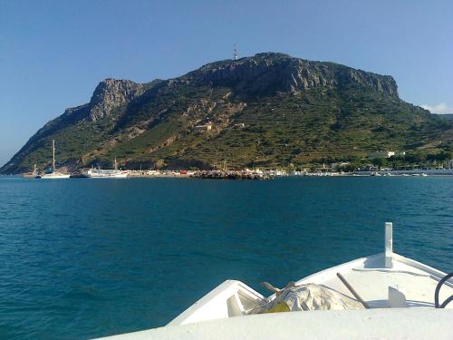 a boat in the water with a mountain in the background at Dionysia Studios in Kefalos