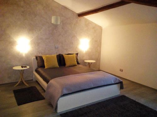 a bedroom with a bed and two lights on the wall at H5-5H Luxury Room in Maranello