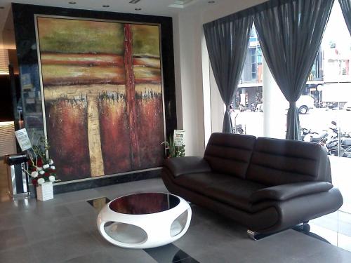 a living room with a couch and a large painting at The Imperial Hotel in Kluang