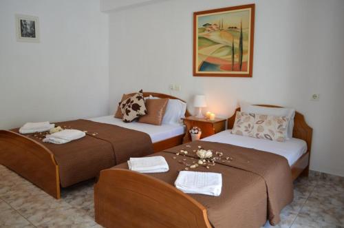 una camera d'albergo con due letti con fiori di Katerinas Apartments a Néos Marmarás