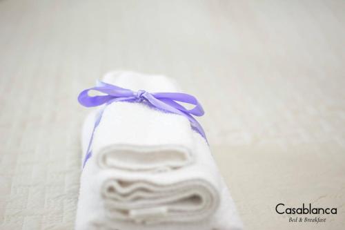 een wit voorwerp met een paars lint eraan bij Casablanca Bed & Breakfast in Rende