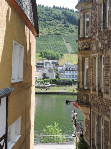 a man standing on a balcony looking out at a river at Pension Winnemuller in Cochem