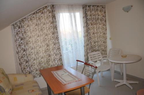 sala de estar con mesa, sillas y ventana en Hotel Babeva, en Sveti Vlas