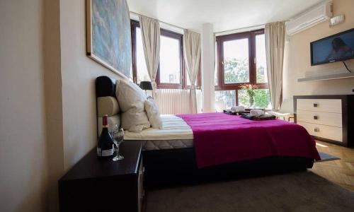 - une chambre avec un lit et une couverture rose dans l'établissement Visoki Stevan Apartments, à Belgrade
