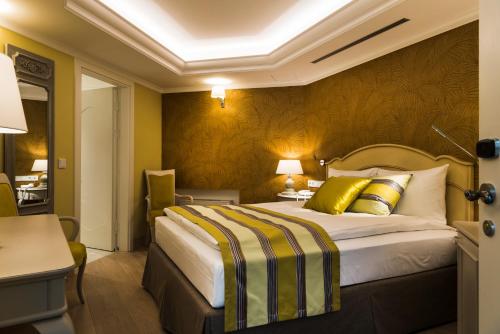 a hotel room with a bed with yellow walls at Relais Le Chevalier in Rīga
